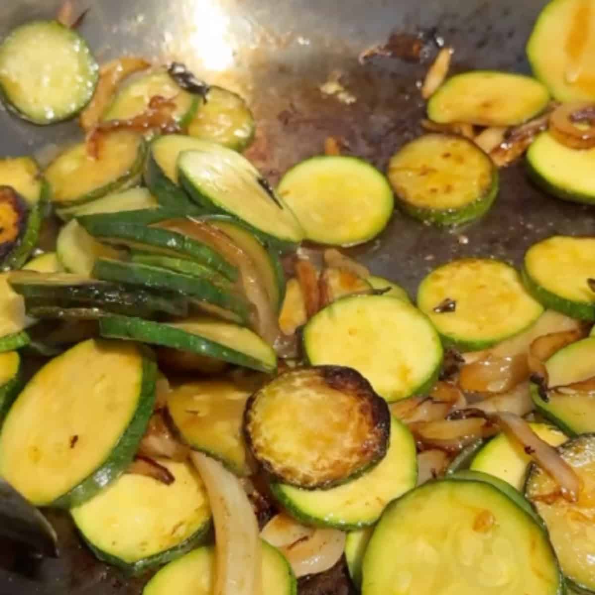 saute onion and zucchini in a pan.