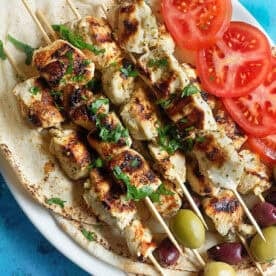 Chicken souvlaki on a platter.