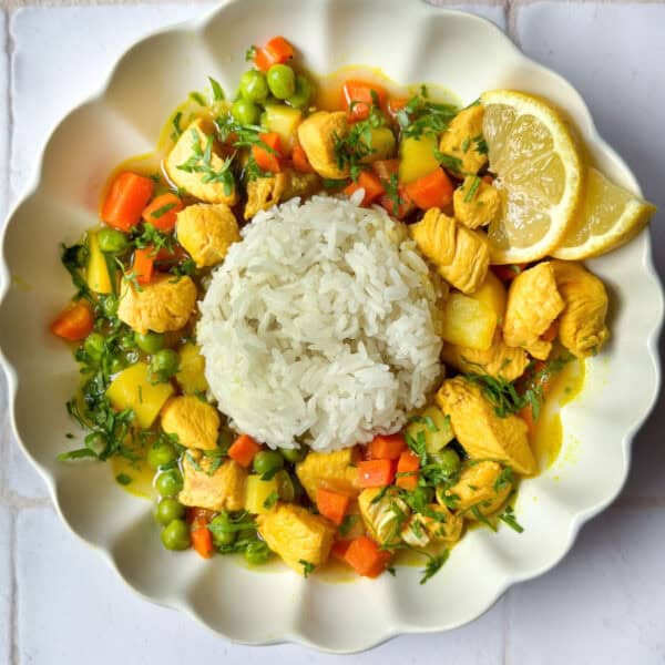 Turmeric lemon chicken soup in a bowl with rice.