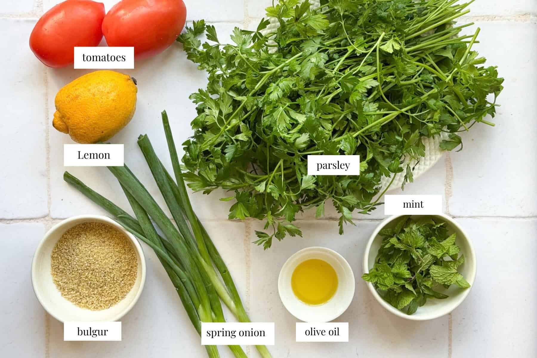 tabouli ingredients are parsley, green onion, mint tomatoes, bulgur, olive oil and lemon.
