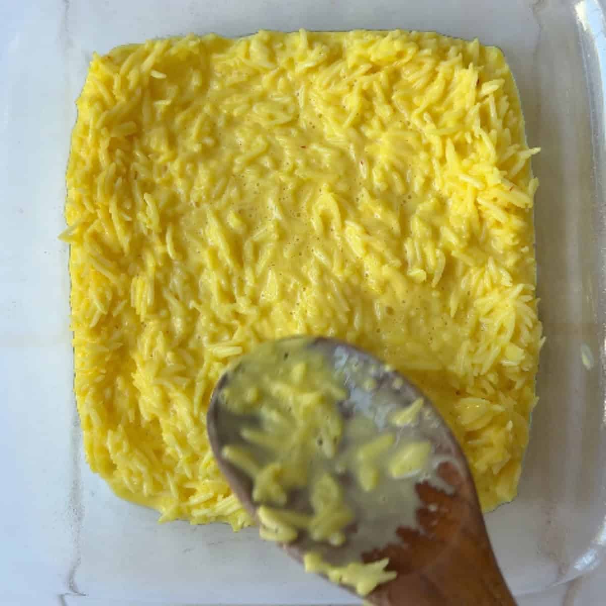 spread half of the rice in the pan.