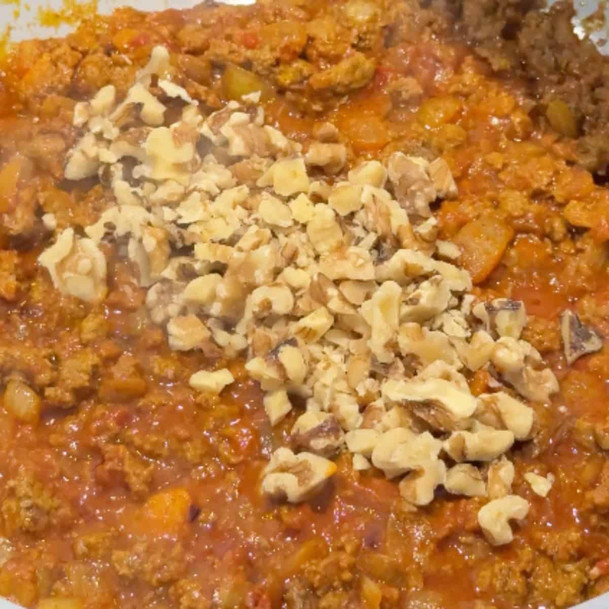 Make the filling by sauteing ground beef with spices and walnuts.