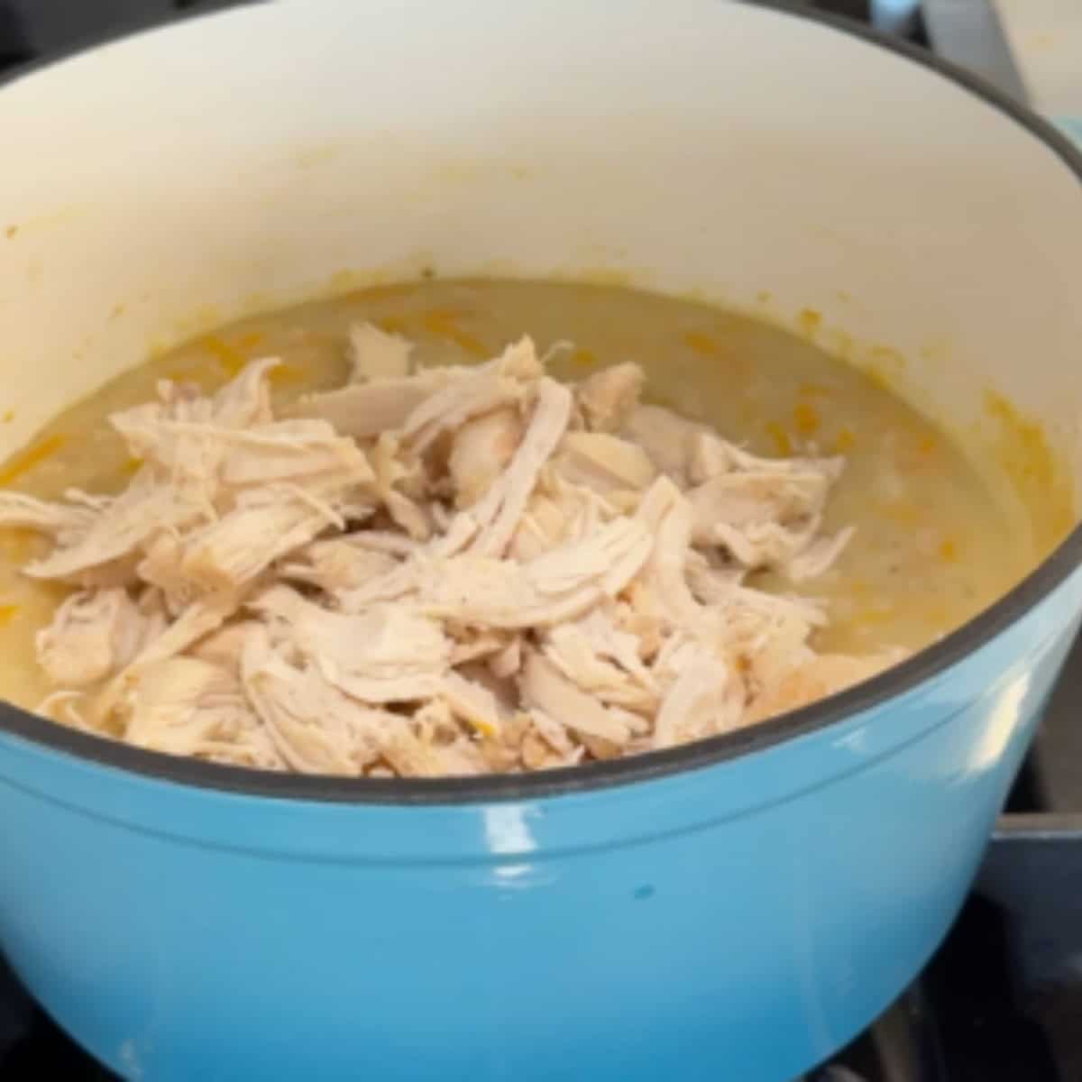 Once teh chicken is cooked, shred and return it to the pot.